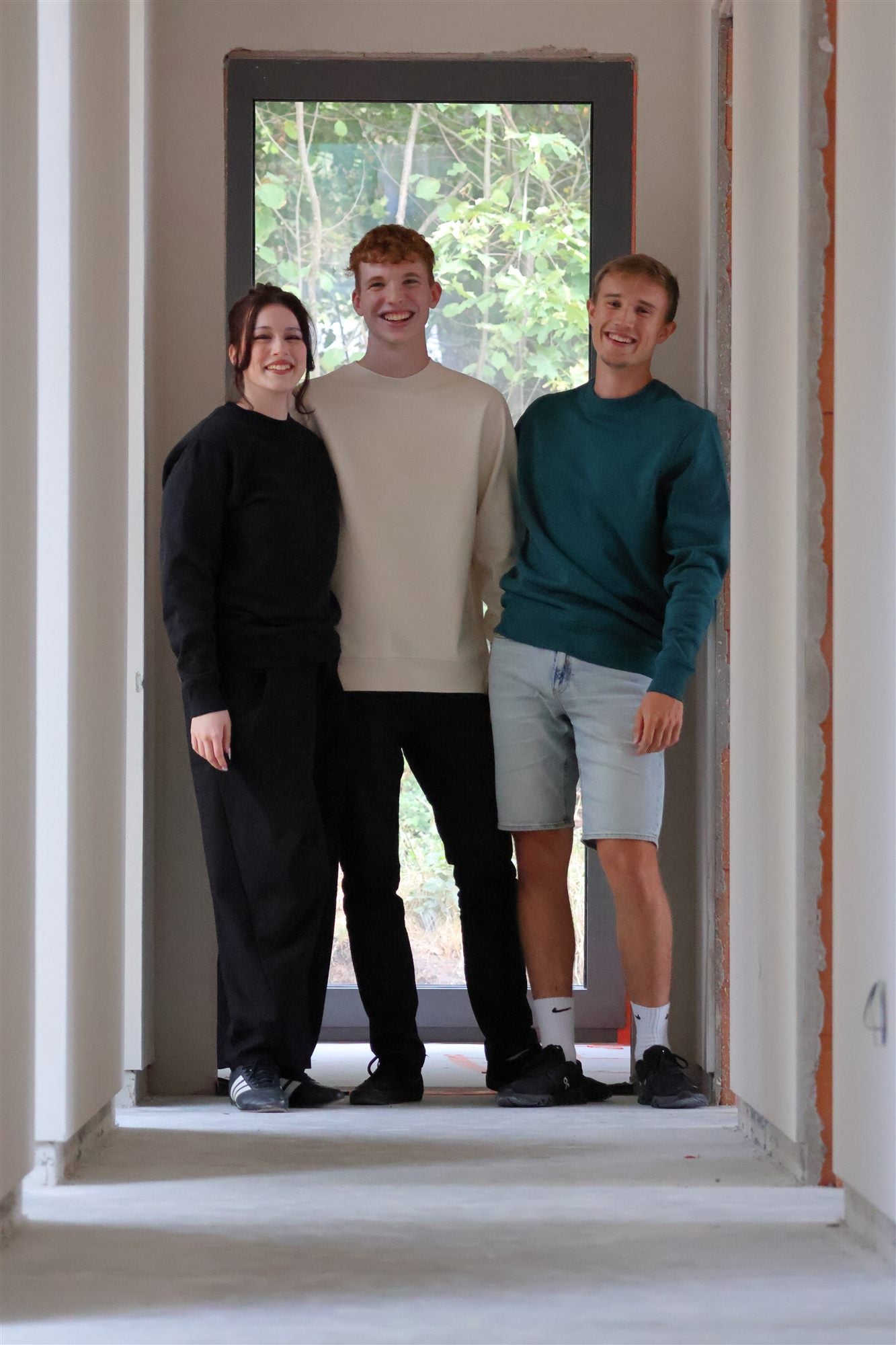 Essentials crewnecks in natural and racing green, shot in an unfinished house